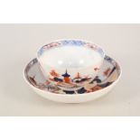 A Lowestoft tea bowl and saucer with dolls house pattern,