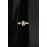 A gold diamond ring with two diamonds to centre flanked by two diamonds either side on shoulders,