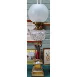 A Victorian brass column oil lamp with cranberry stem and cut glass bowl