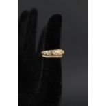 A yellow metal snake ring with engraved detail,