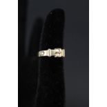 A gold ring of buckle design set with small diamond,