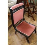 An Edwardian ebonised pink velvet upholstered nursing chair