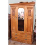 An Edwardian satinwood carved double wardrobe with three drawers below