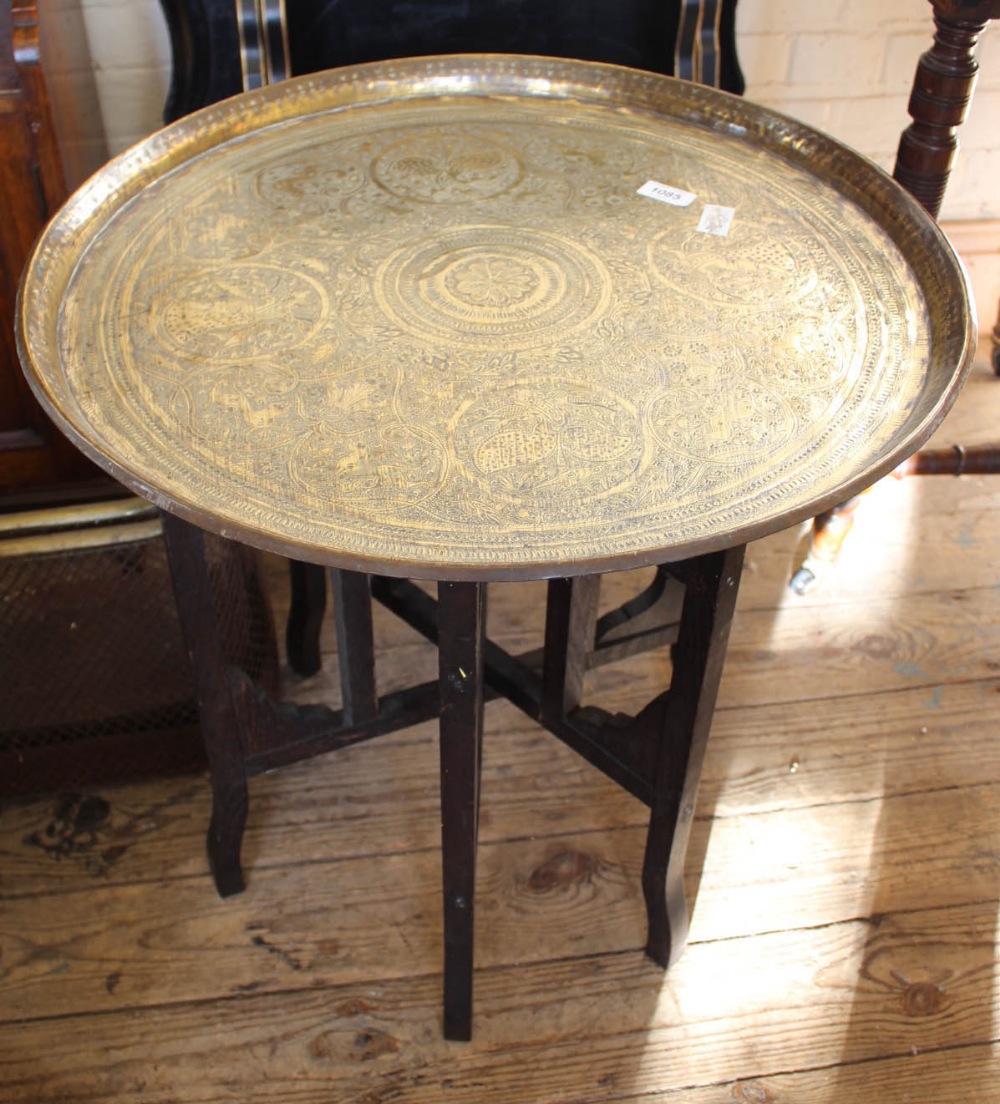 A Moroccan style brass table on collapsible stand