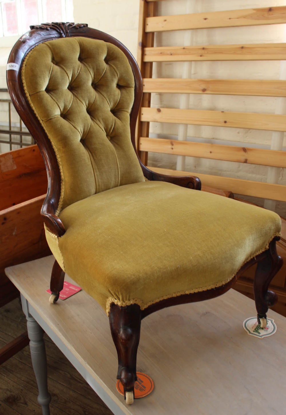 A Victorian mahogany balloon back nursing chair with gold button back upholstery