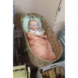 A folding dolls cot containing Armand Marseille porcelain head doll,