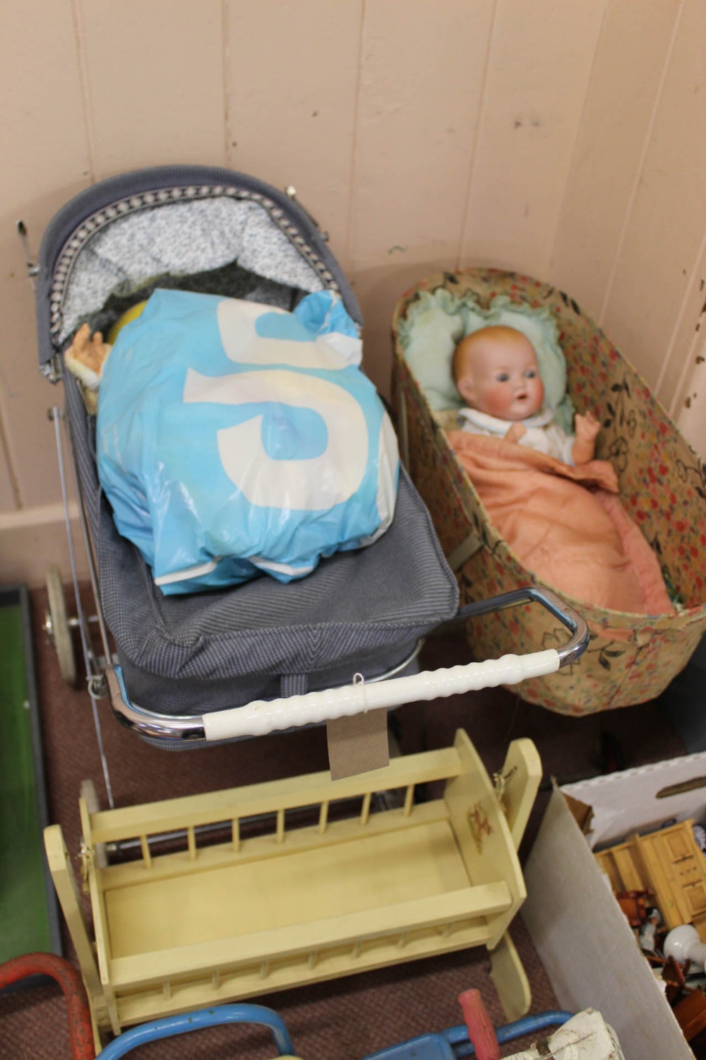 A 'classic' dolls pram and vinyl doll plus clothes and a wooden cradle