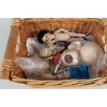 A basket of small dolls including porcelain heads