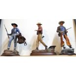 Three John Wayne 'Cowboy Legend' hand painted porcelain figures on wooden plinths