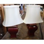 A pair of maroon and gilt table lamps with lion ring handles