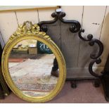 An oval gilt wall mirror plus a shaped metal and mesh fire screen