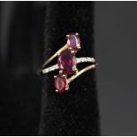 A 9ct gold ring set with three pink stones and diamonds,