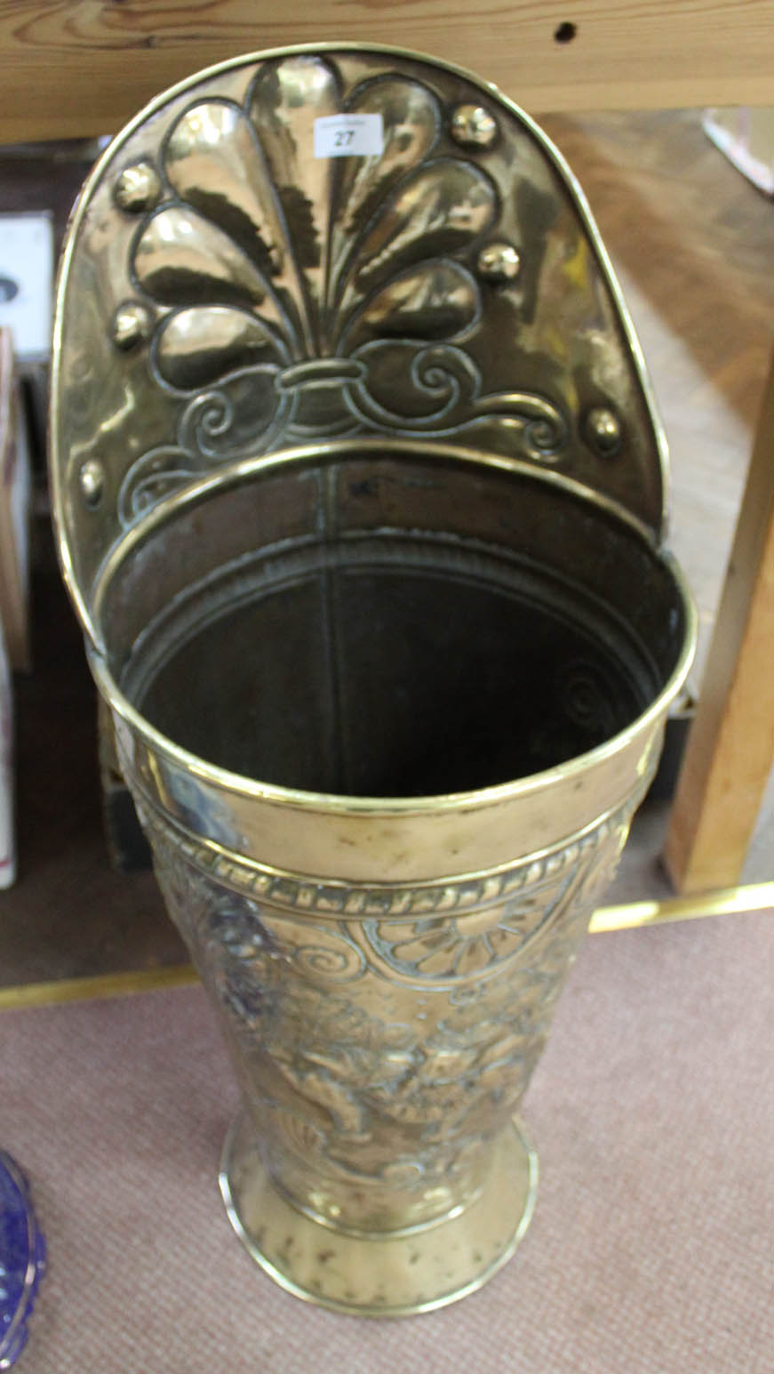 A 19th Century Dutch brass stick stand in the form of a grape hod highly embossed with figures in