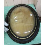 An ebonised and gilt oval picture frame with convex glass,