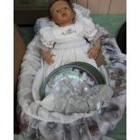 A rubber dressed doll in cot plus various wall plates