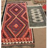 A geometric flat weave rug plus a small Pakistan rug