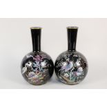 A pair of Victorian black glazed bottle vases with peacock and floral decoration