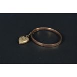 A 9ct rose gold bangle with engraved detail (dented) with a 9ct gold back and front heart shaped