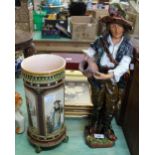 A German pottery figure of a boy and urn plus a 19th Century Mettlach figure painted vase (cracked)