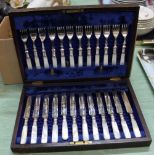 A mahogany canteen of mother of pearl handled silver plated tea knives and forks