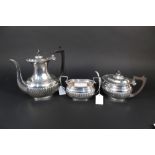 A three piece silver tea set comprising of water jug, teapot and sugar bowl of half fluted design,