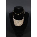 A 9ct gold and silver necklace with 9ct gold chain suspended from main bar which has fine 9ct gold