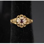 A lady's 18ct gold ring set with red stone and small diamonds (one missing),