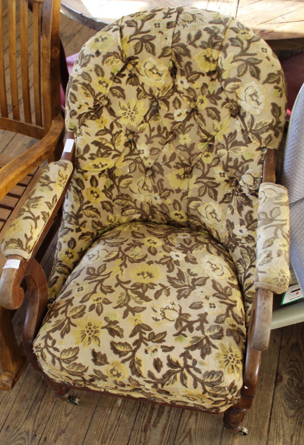 A Victorian floral upholstered button back armchair on brass castors