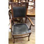 An Edwardian mahogany high back armchair with studded black leather upholstery