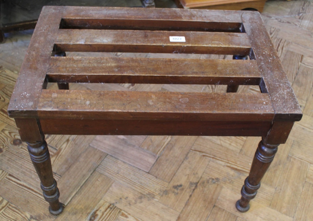 A mahogany luggage stand with turned legs