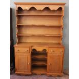 A modern oak effect shelf back dresser with two drawers and two door cupboard below