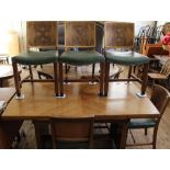 An Art Deco figured walnut draw leaf dining table on solid end supports and a set of six matching