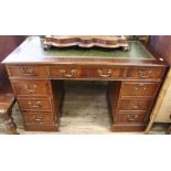 A reproduction nine drawer pedestal desk with green leather inset top