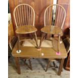 An oak rectangular extending dining table with four stick back chairs