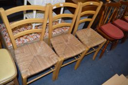 Three Rush Seated Beech Framed Dining Chairs
