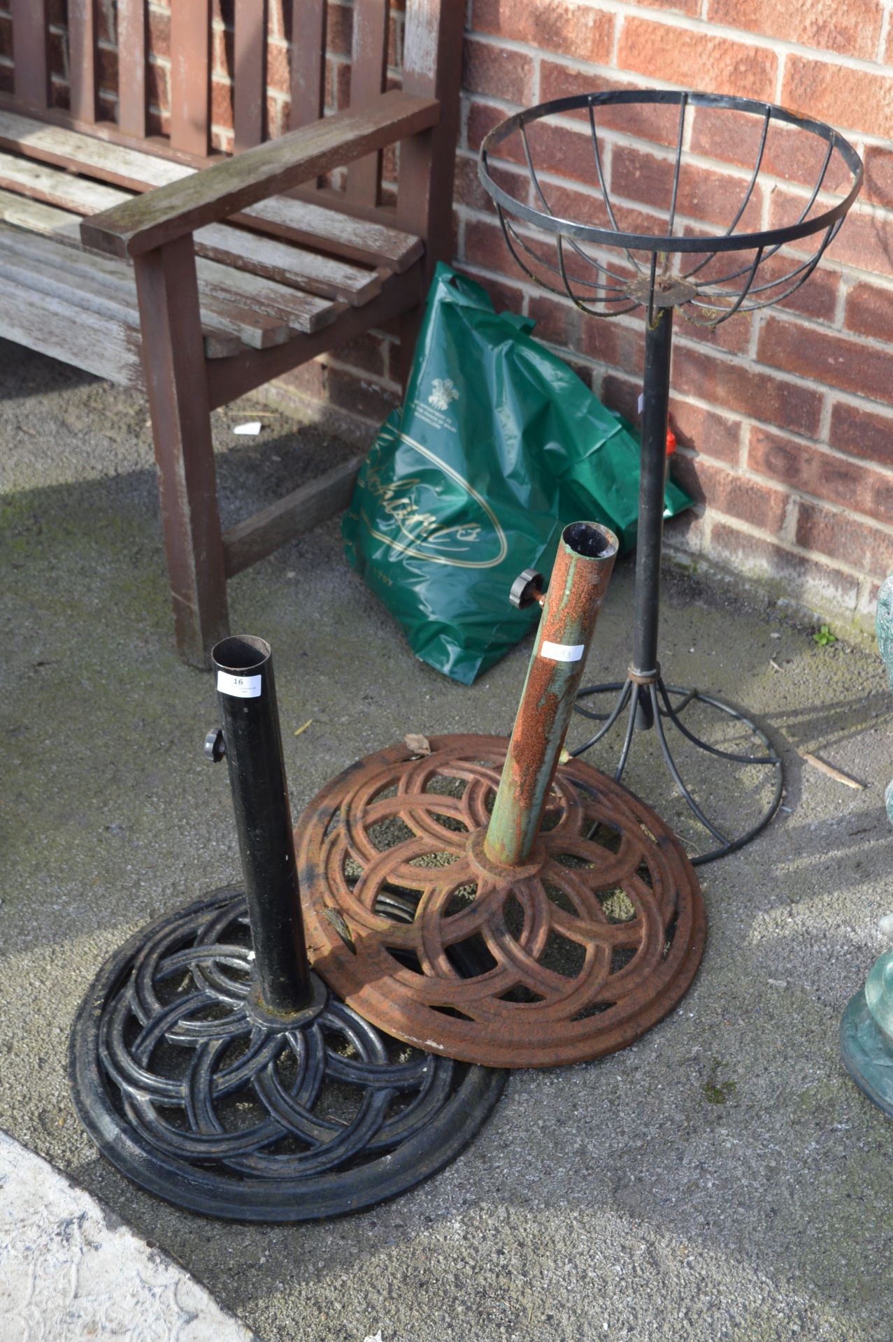 Two Metal Parasol Stands and a Metal Flower Baske