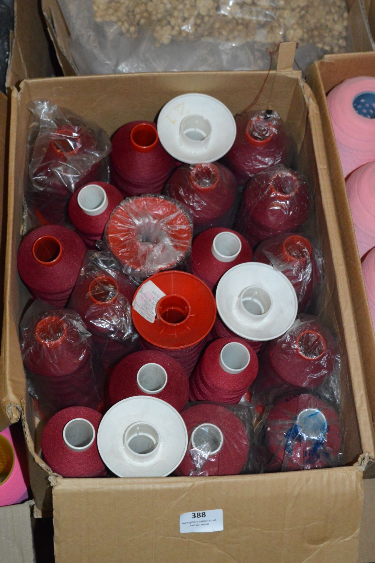 Box Containing Nineteen Cones of Burgundy Polyester Thread