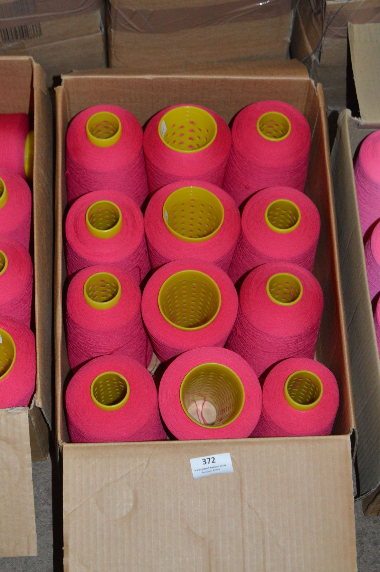 Twelve Cones of Red Polyester Thread