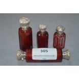 Four White Metal Topped Ruby Glass Scent Bottles