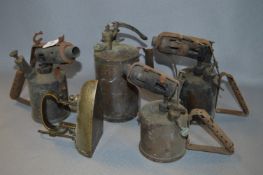 Four Brass Flame Lamps and a Brass Iron
