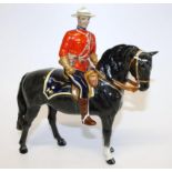 A Beswick figure of a Mountie, on black horse, with blue seat marked MP, with man in military