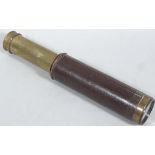 An early 20thC brass two draw telescope, with pressed leather end, unmarked (when extended) 37cm