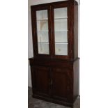 A Victorian mahogany bookcase, the two glazed doors hinging to reveal a fixed interior raised