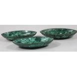 Three various malachite dishes, each of shaped ellipse form, with shaped outer banding on oval feet,