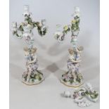 A pair of Continental porcelain Sitzendorf style candlesticks, each with figural stems set with