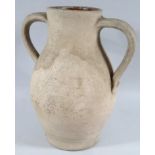 A hand thrown pottery ewer, with two handles and bulbous body, of plain outline, with a brown