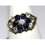 A ladies 18ct gold ring set, florally set with white and blue stones, on a plain shank marked 750.