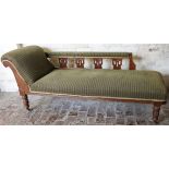 An Edwardian walnut framed chaise longue, upholstered in green striped material on shaped