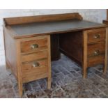 An early 20thC pine desk, with one piece green leather top with a galleried back raised above two