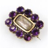 A 19thC brooch, with shaped oval outline, set with purple stones, with an entwined lock of hair